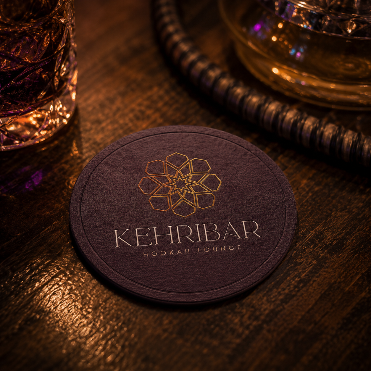 Kehribar Hookah Lounge branded coaster featuring the amber geometric logo system